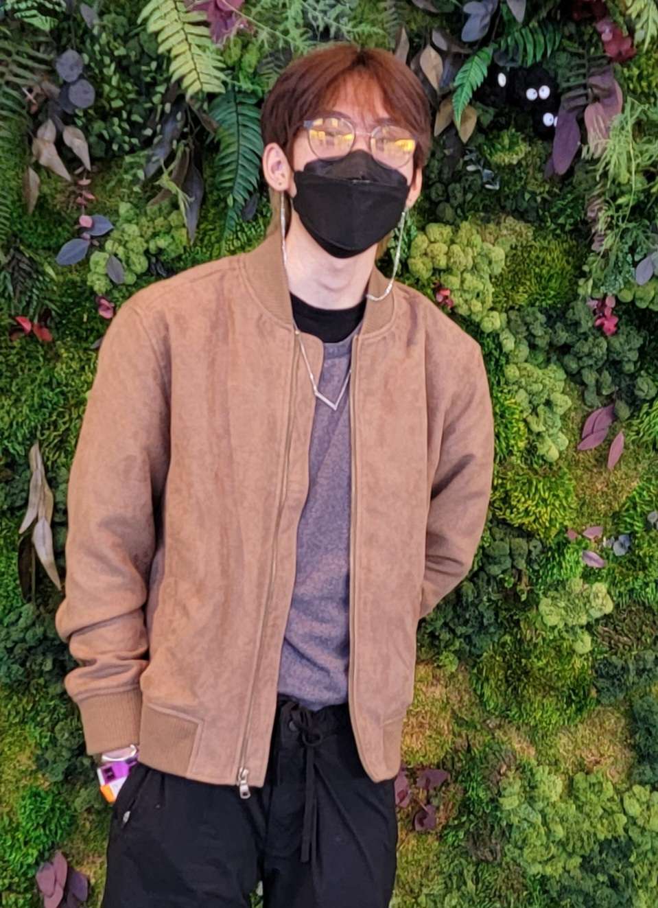 Noah Hoang with black facemask and foliage backdrop